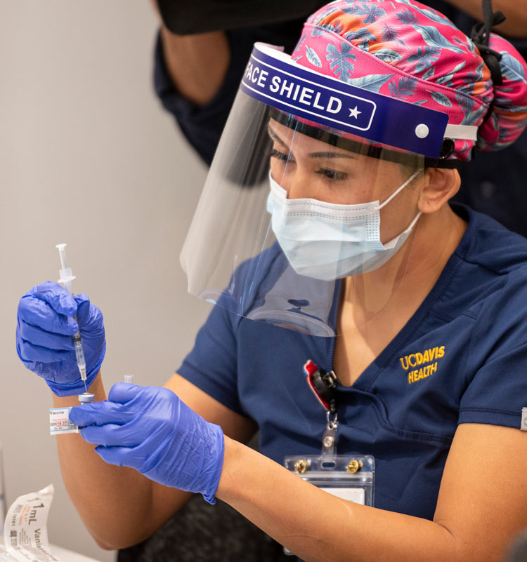 Nurse fills syringe.