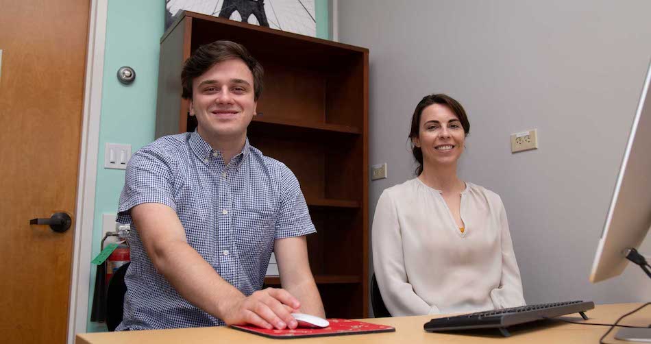  William Cole and Associate Professor Breanna Henn sit down at a computer together. 