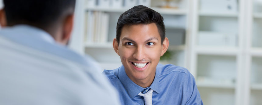 Man smiling behind desk