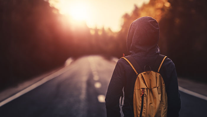 Student with backpack on path