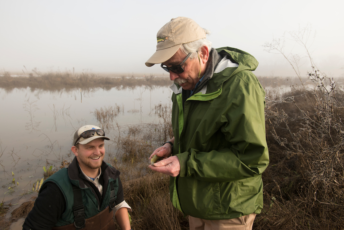 Peter Moyle inspects a fish with a smiling Devon Lambert