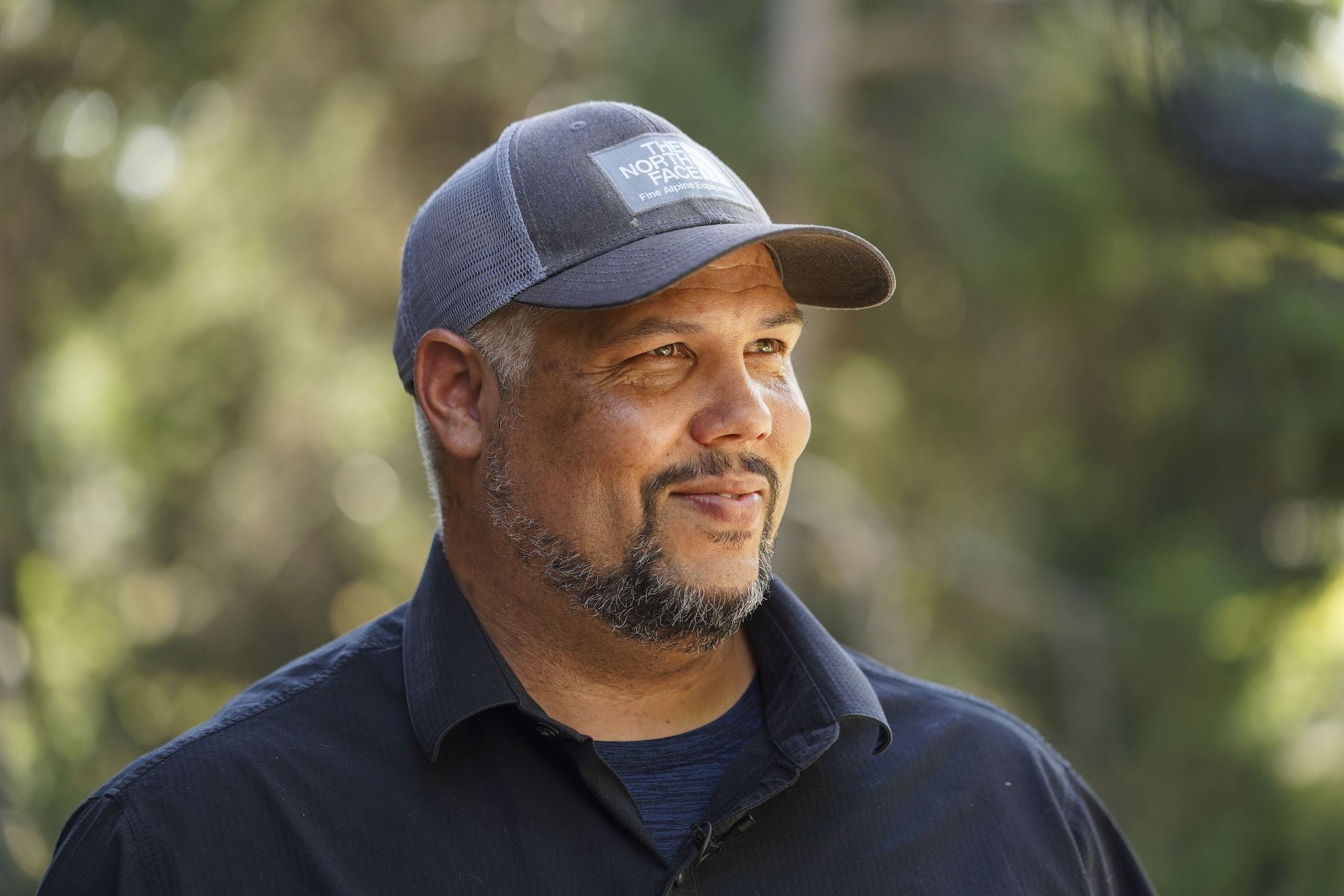 Profile of Levi Lewis with forested background