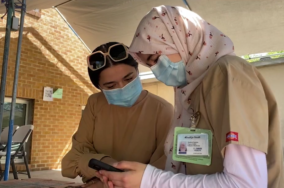 Two women look at information on a cellphone