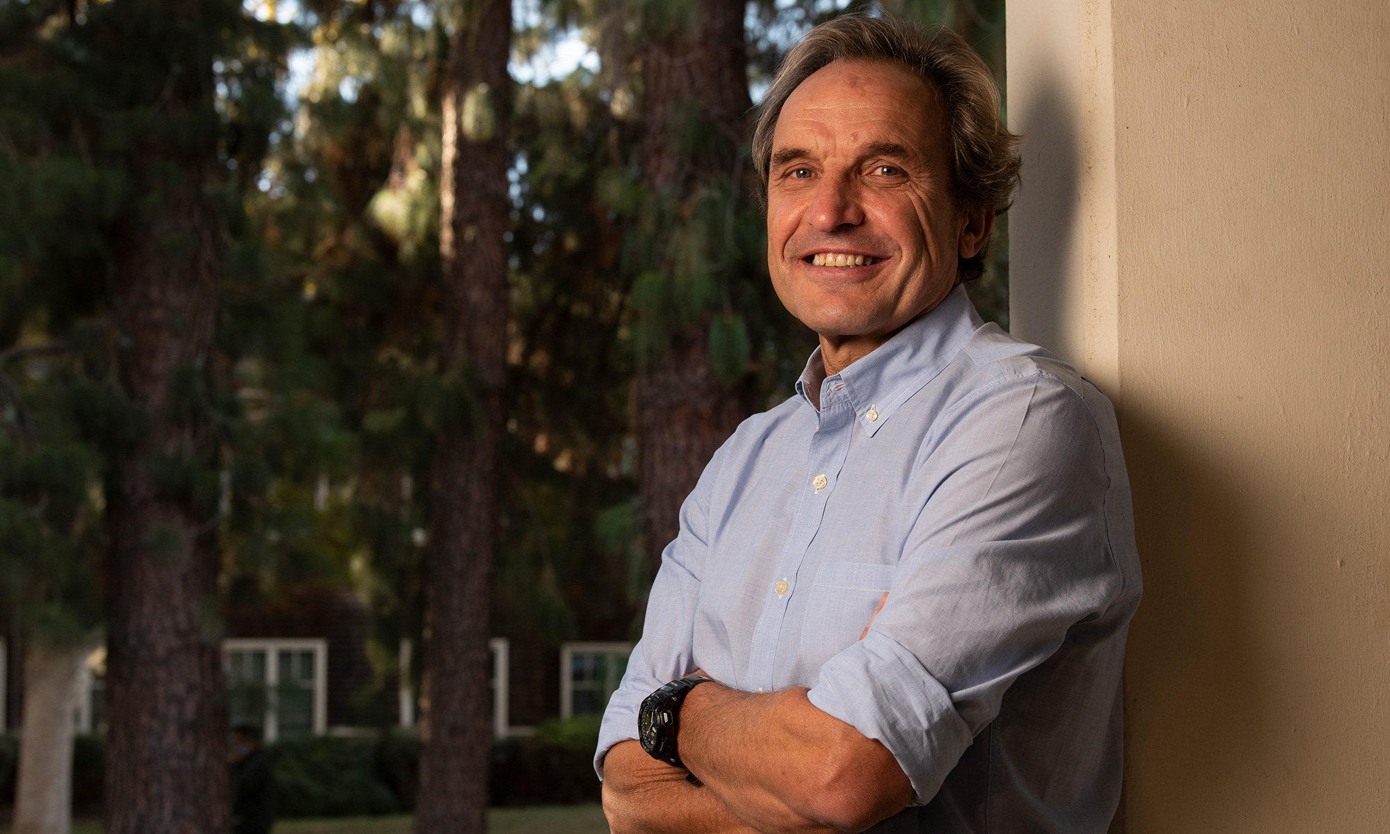 Emilio Ferrer leans against a building column on campus