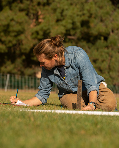 Haven Kiers measures grass as part of sheep mowers project