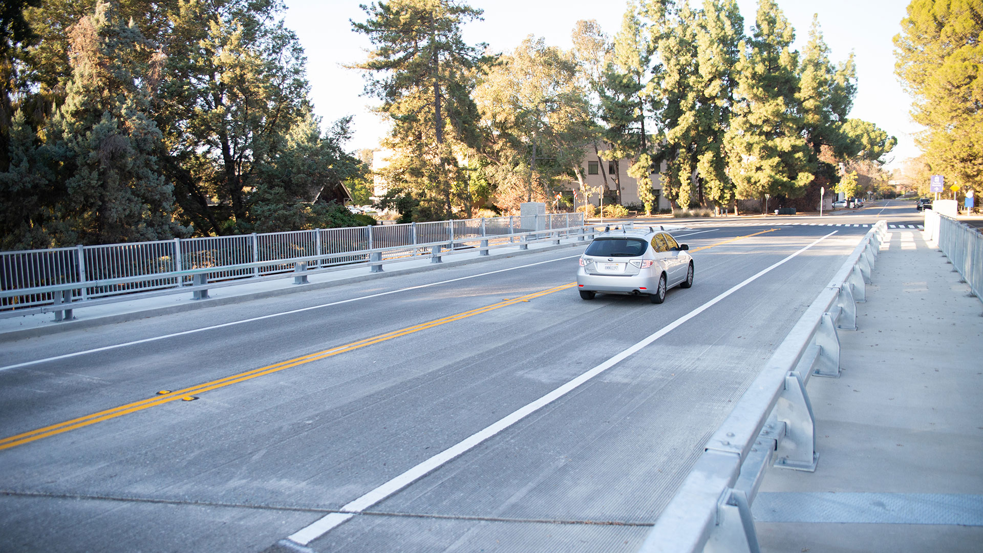 A car crosses a two-lane bridge.