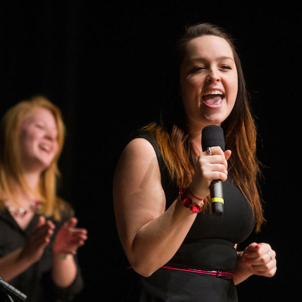 A young woman singing in an accapella competition