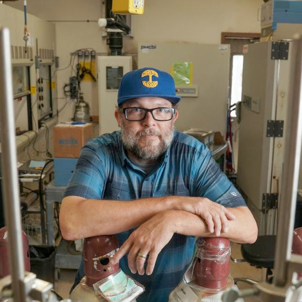 A UC Davis researcher poses for a portrait in his lab