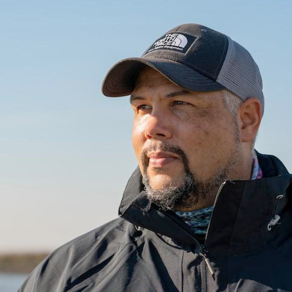 A UC Davis scientist in a hat stares off at the horizon