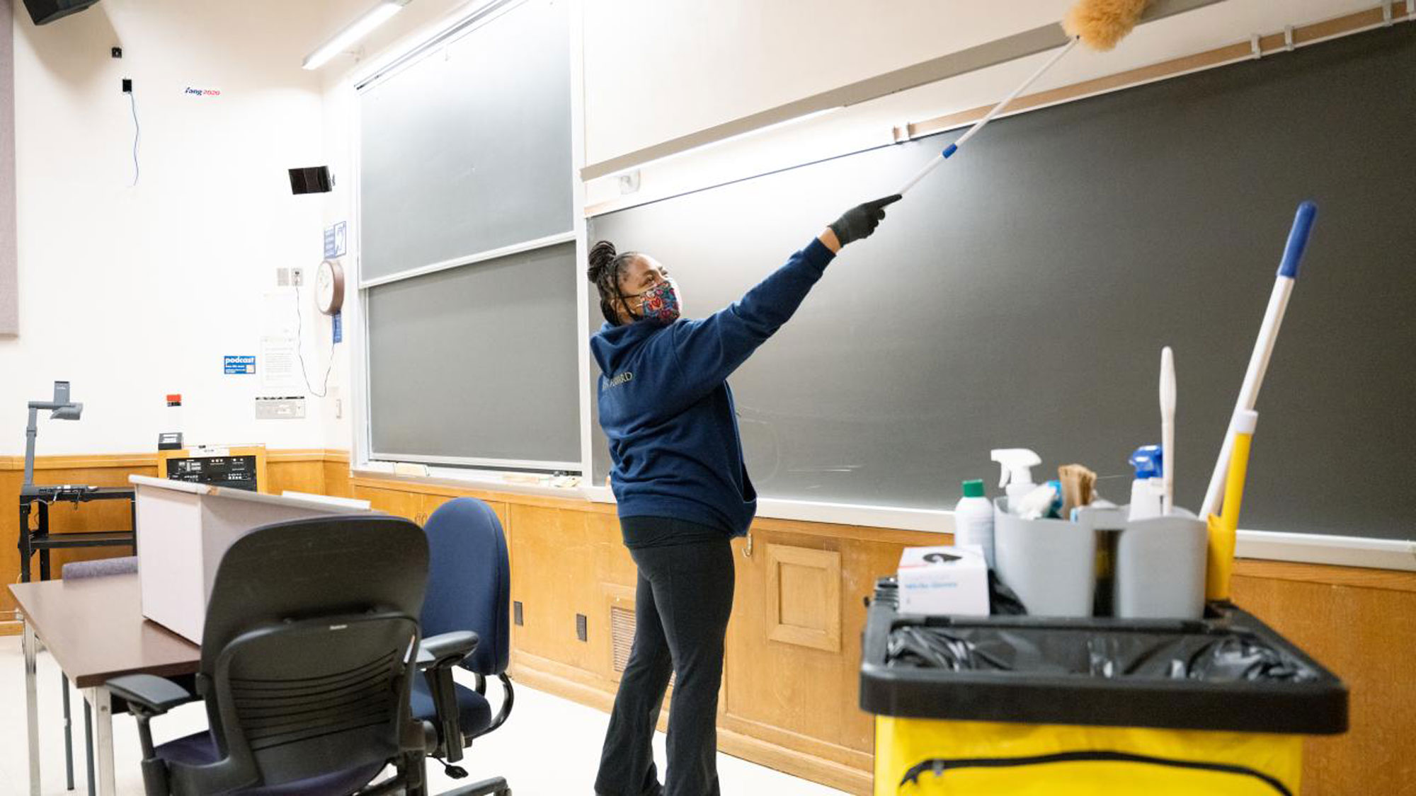 Custodian dusts around whiteboards