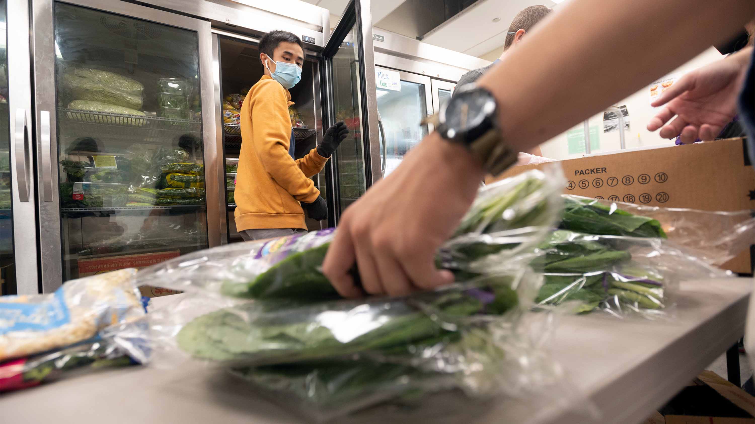 Student turns as hand grabs food on table.