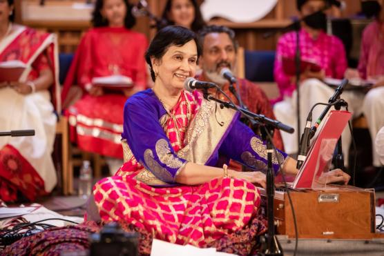 Woman with dark hair in red cultural costume on stage