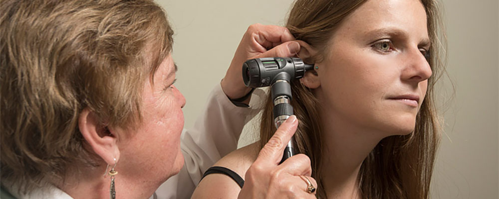 Student gets ear inspected. 