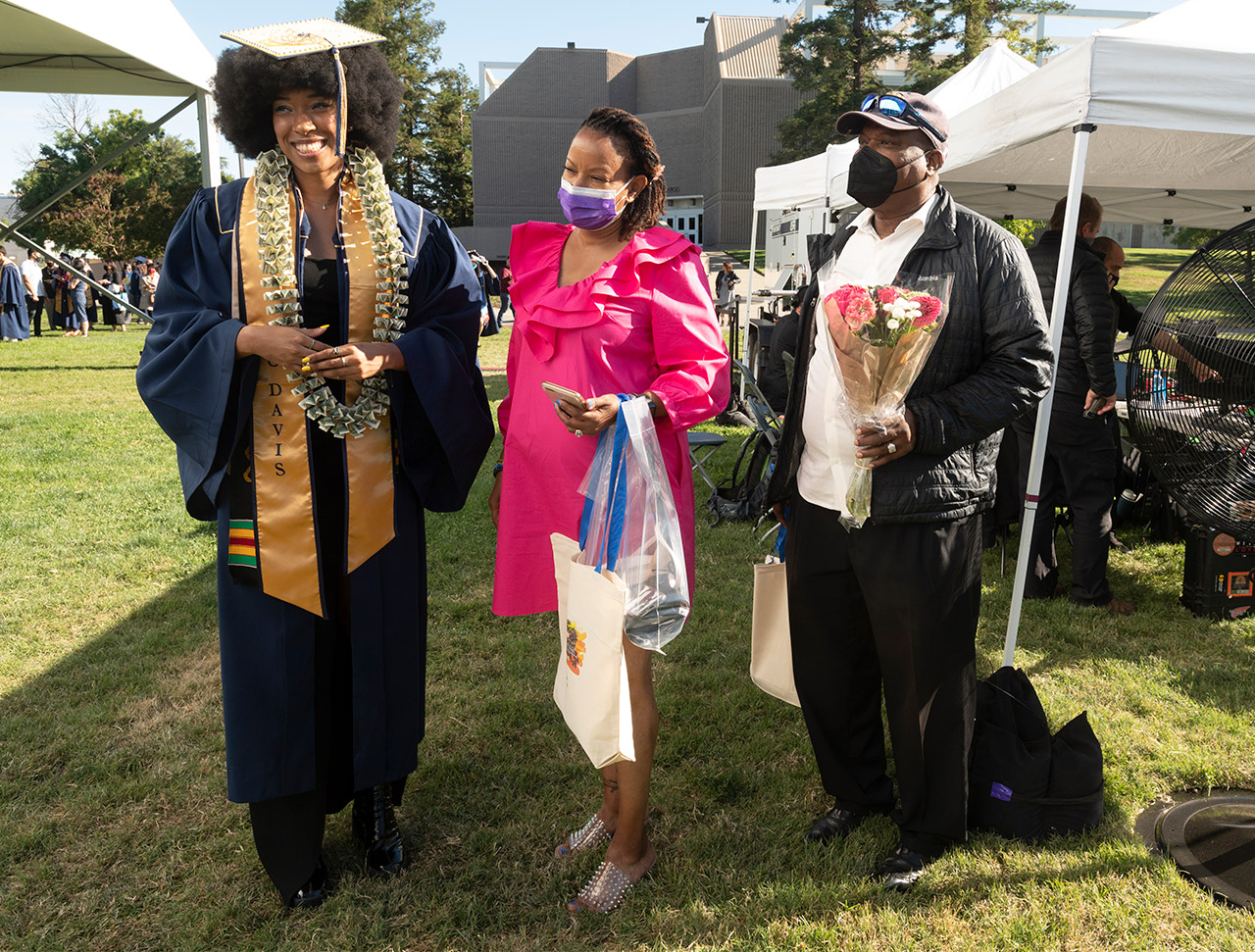 Student with parents at commencement.