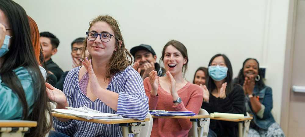 students in a row clapping for a presentation 