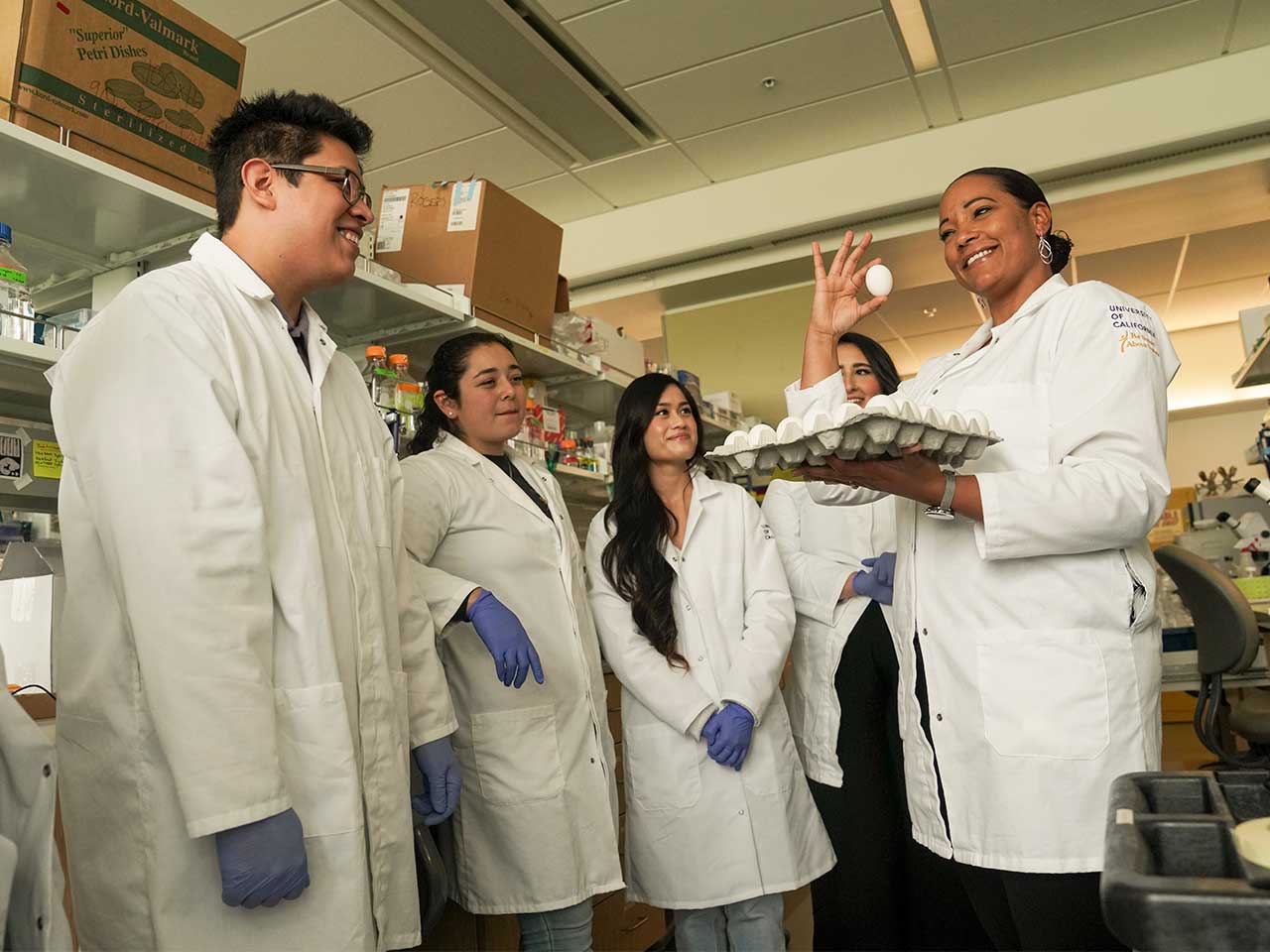 Dr. Crystal Rogers and a group of students hold chicken eggs in Roger's lab in the Vet Med 3B building.