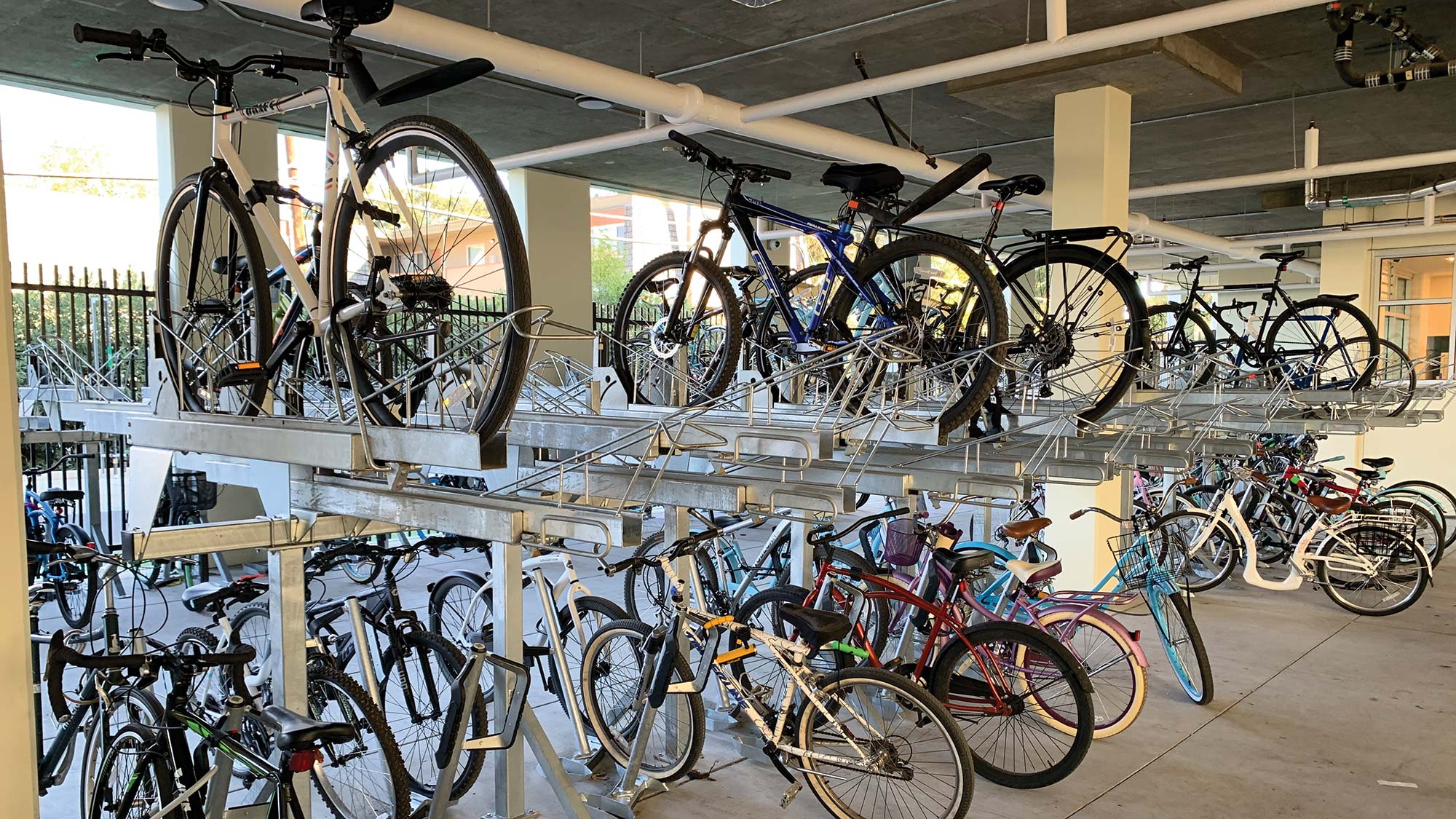 Photo of a dedicated bike storage area underneath the building. Bikes are stacked on upper and lower racks. 