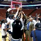 Basketball team posing with trophy.