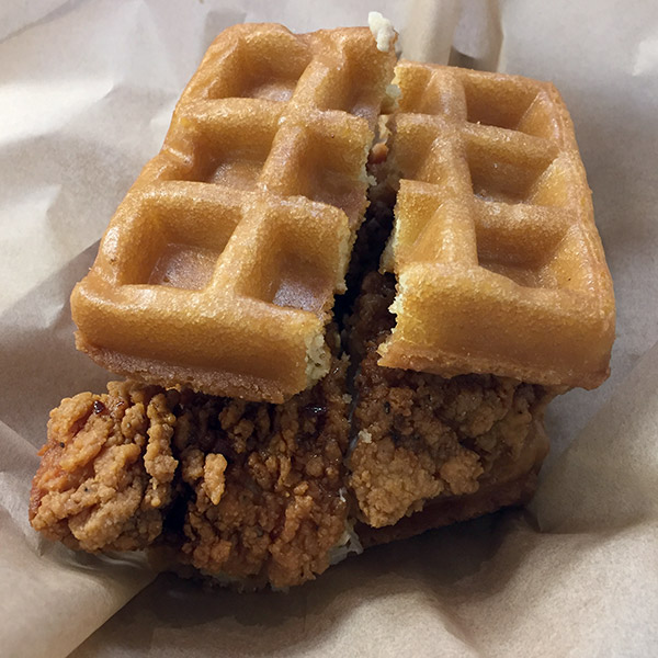 A chicken and waffle breakfast sandwich.