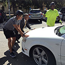 Chancellor Gary S. May helps push a car.