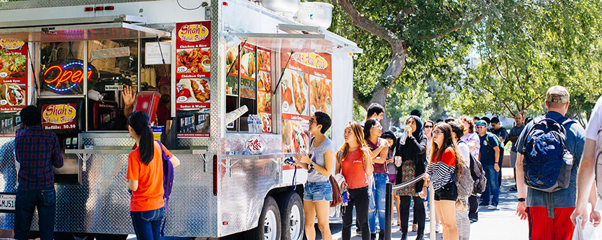 People lined up to get service from a food truck