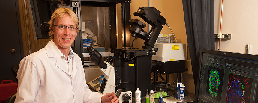 Scientist in white coat sitting in his office