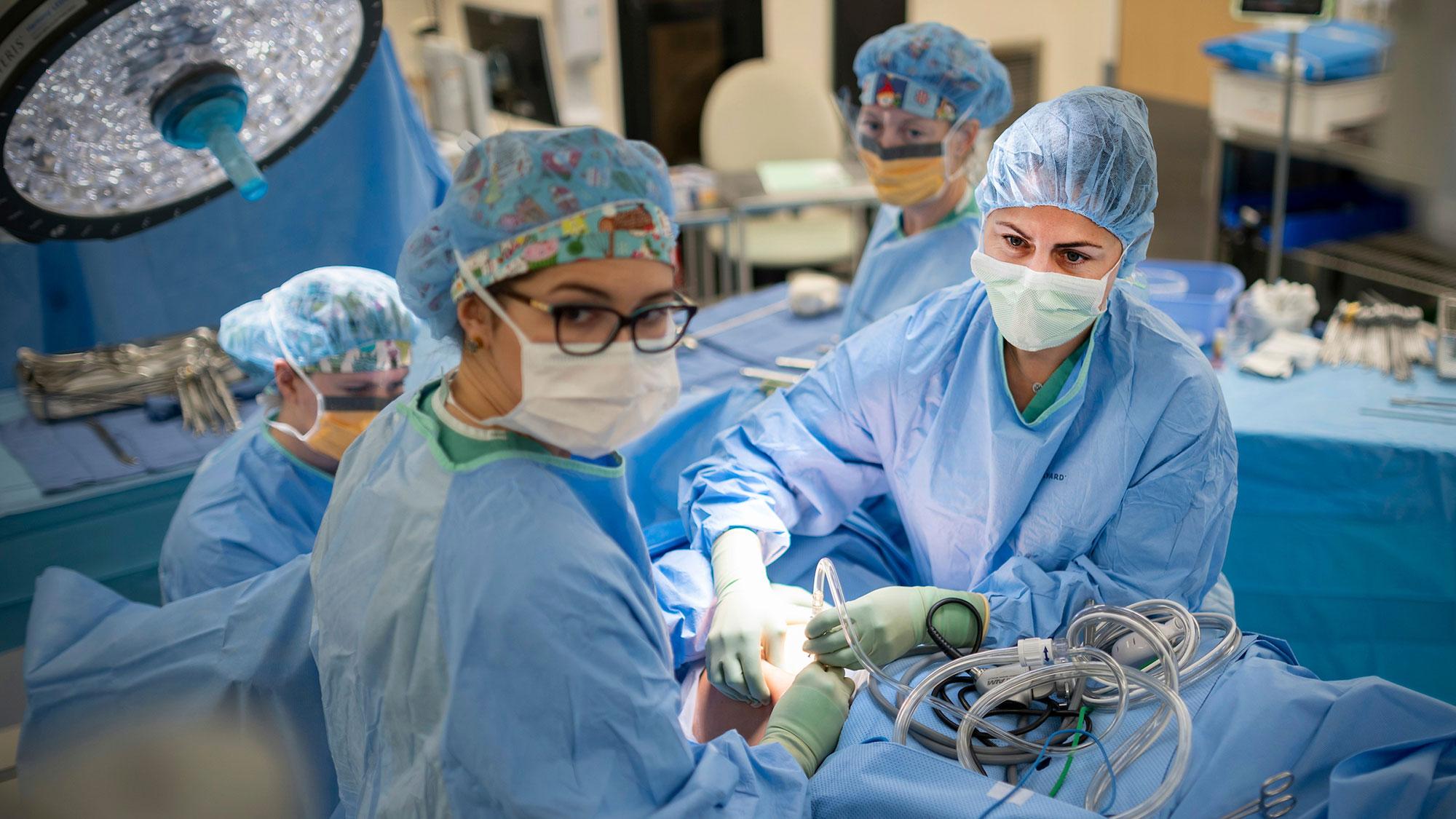 Several doctors operating on a patient using robotic assistance