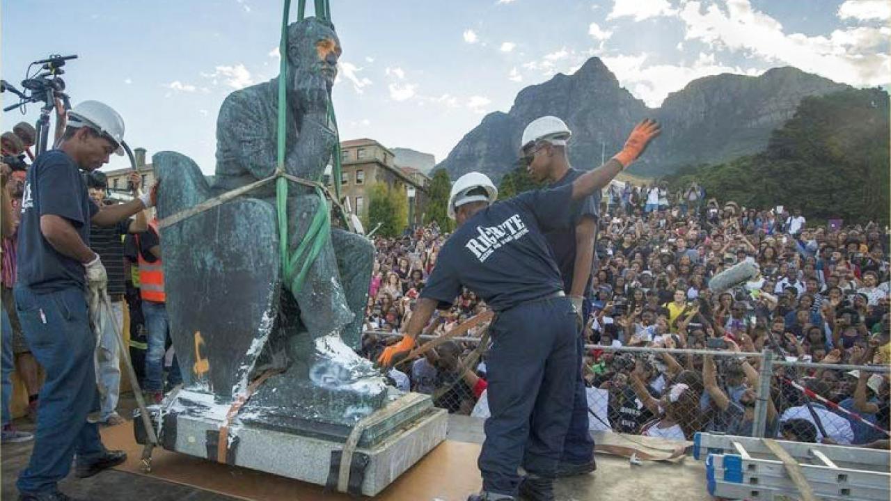 Workers remove a statue.