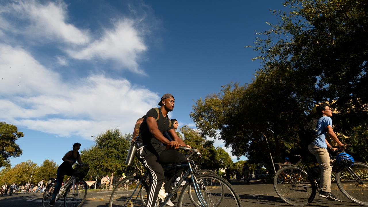 On the first day of classes, students ride their bikes through the bike circle on Hutchison Drive on September 25, 2019.