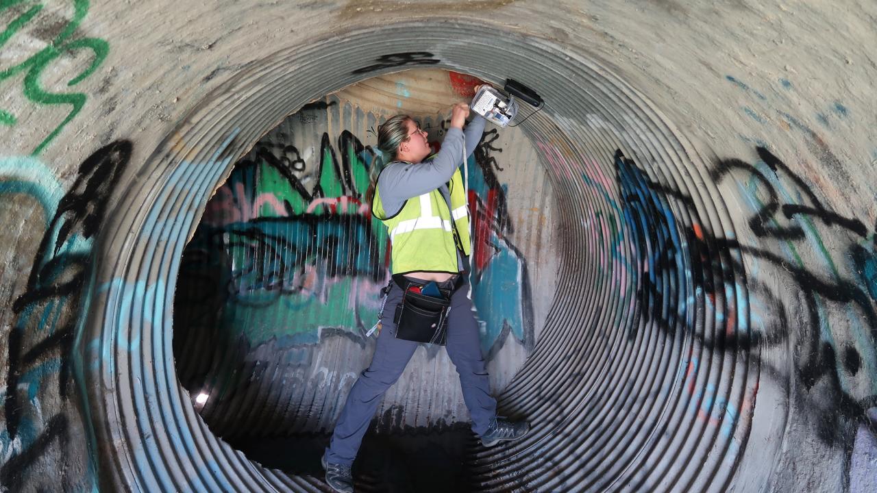 Woman works in a drainpipe