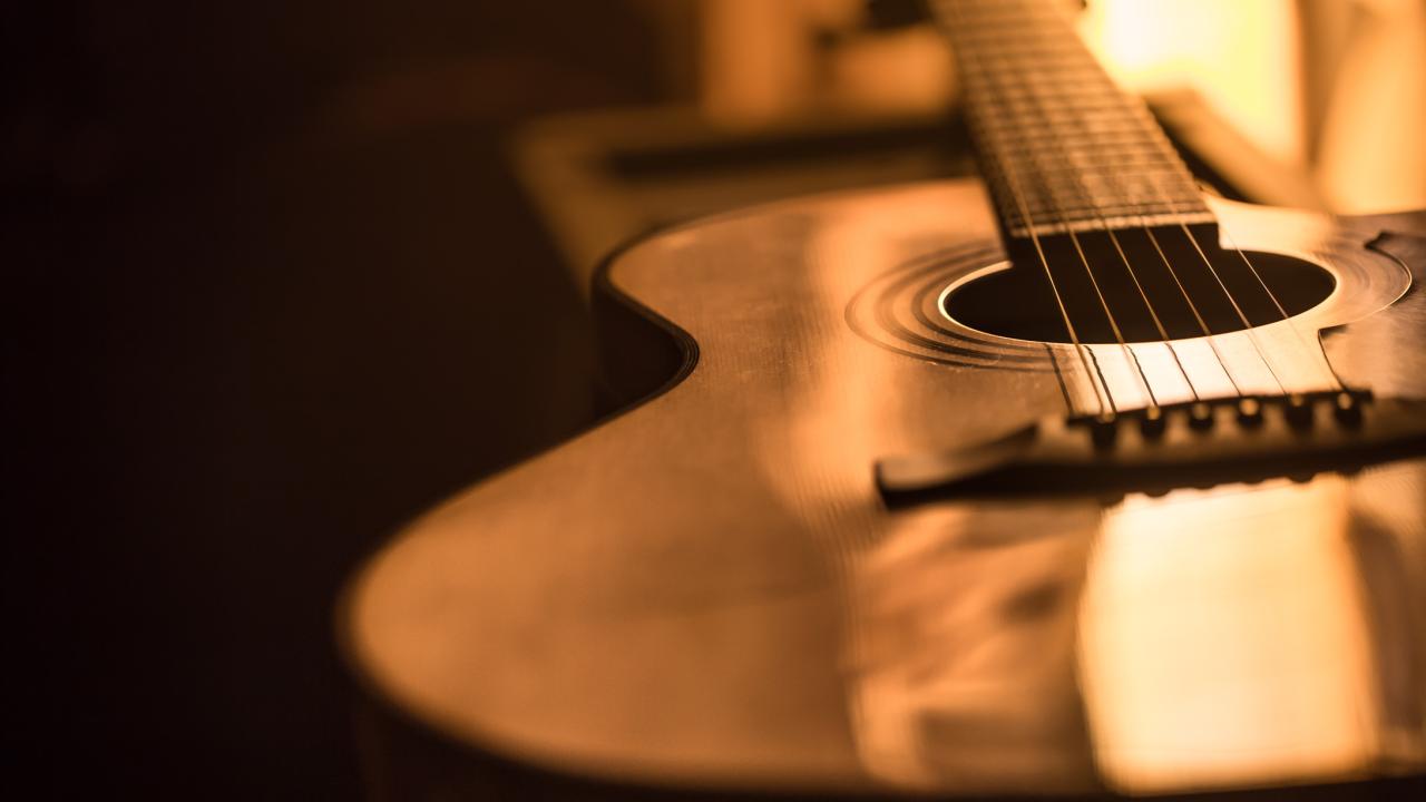 Acoustic guitar, wood, on dark background