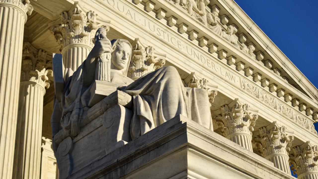 Photo of large government building with statue in front