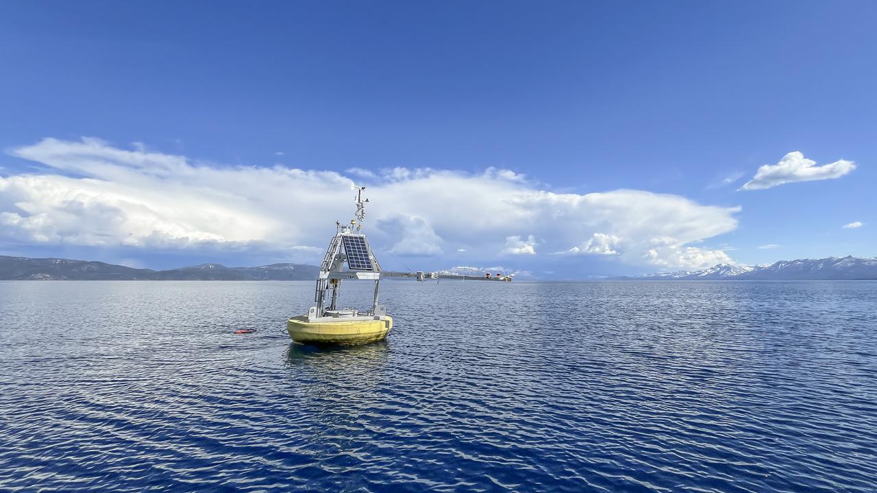 Blue sky above blue water with a floating object just left of photo center. 