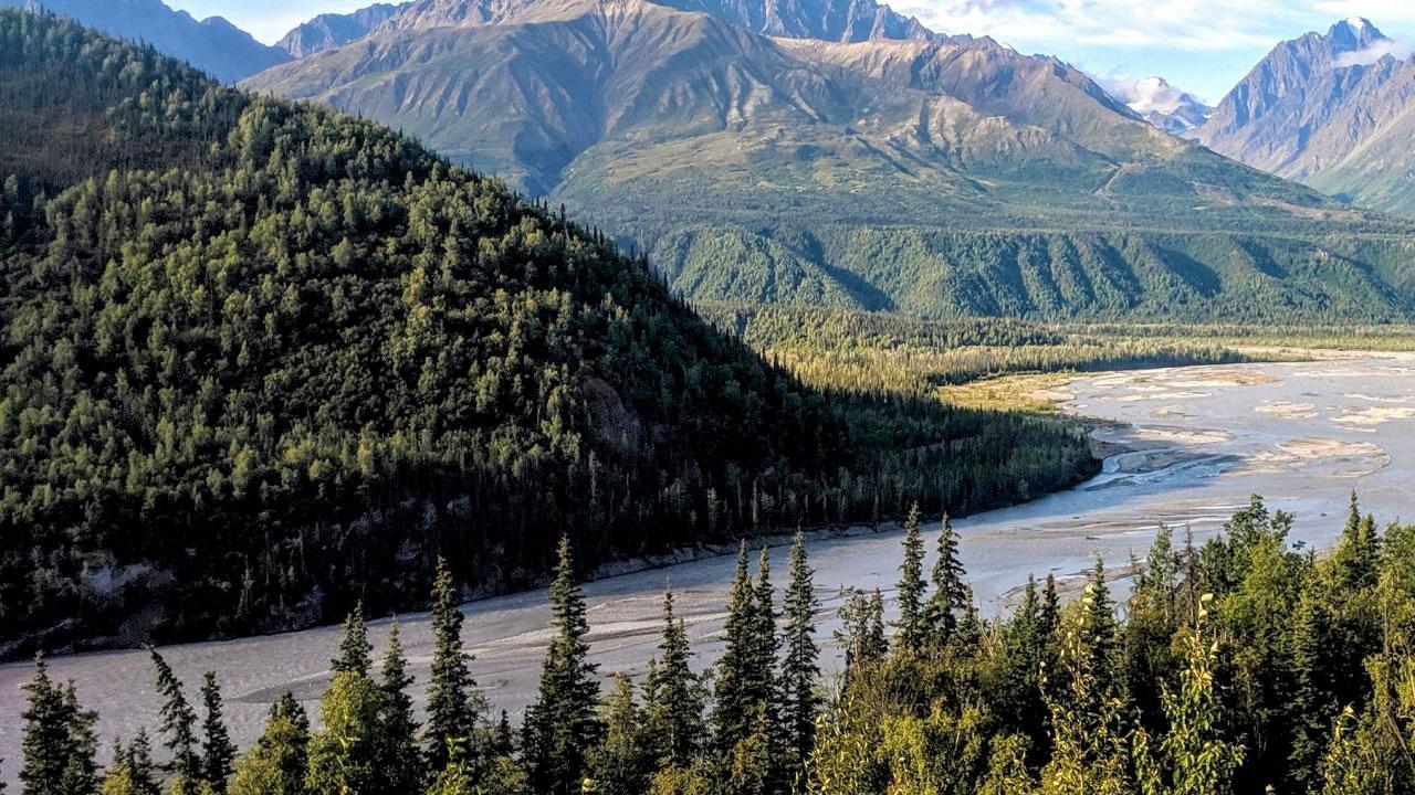 A beautiful mountain scene with a braided river flowing through a glacial valley