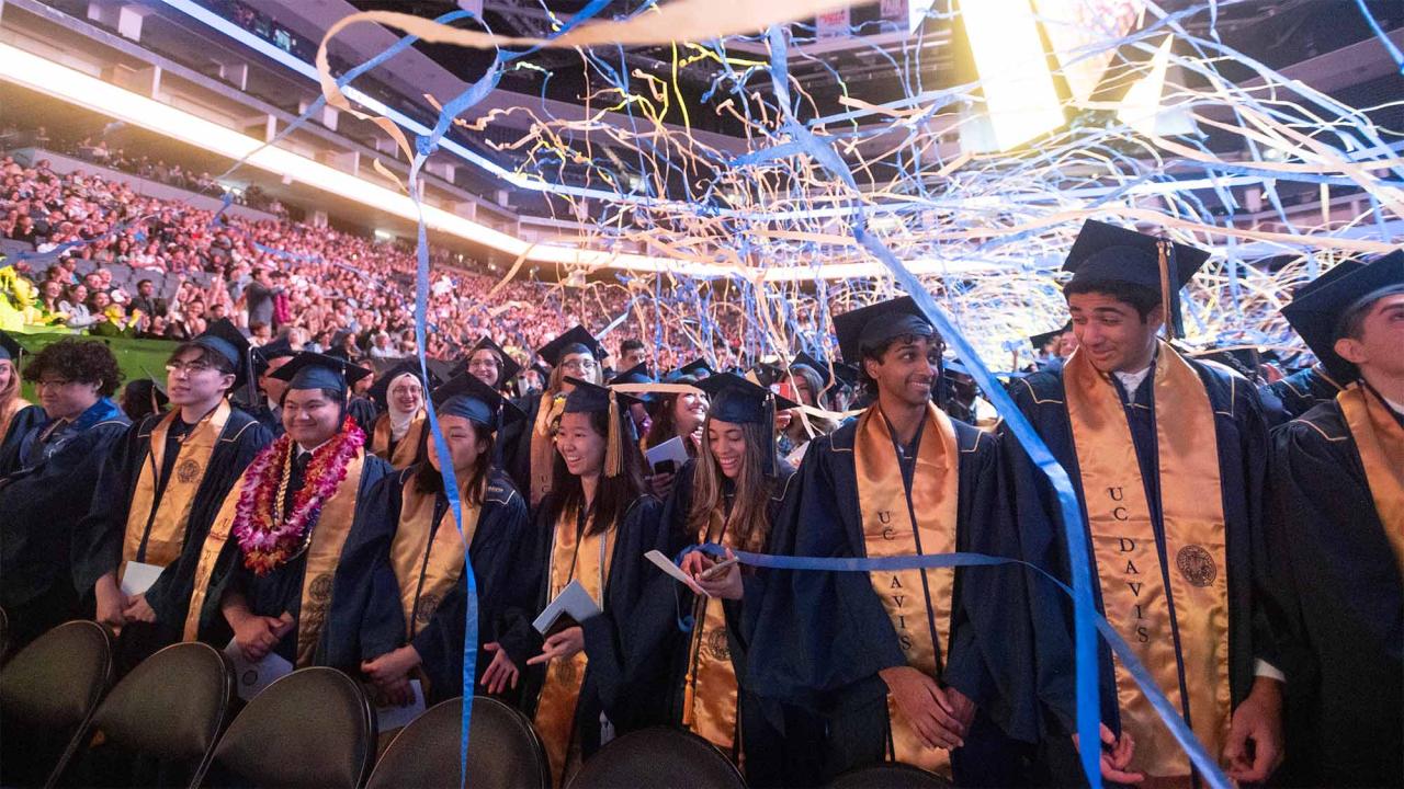 Confetti streamers fall down around graduates