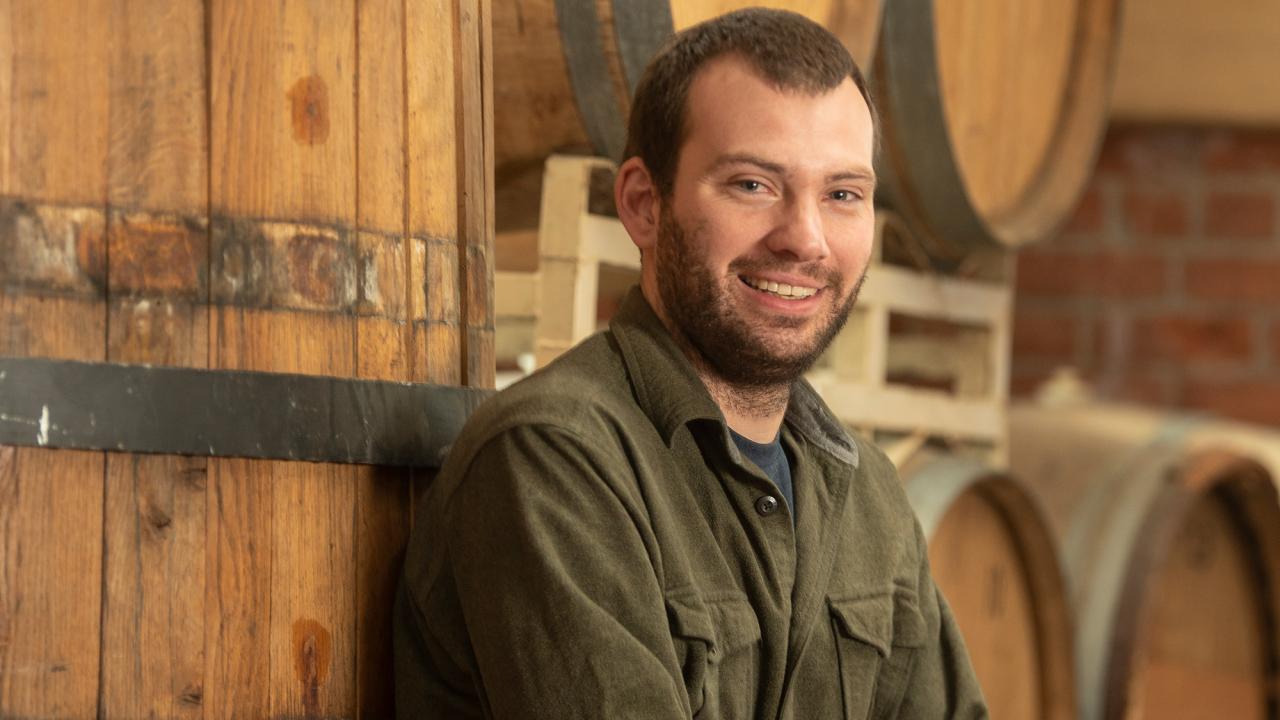 Man leans against stacked beer barrels