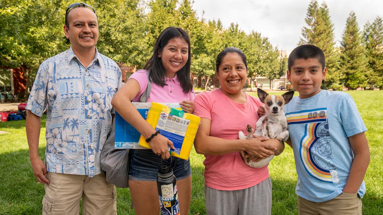 A new freshmen poses with her family on the Tercero quad on UC Davis move in day.