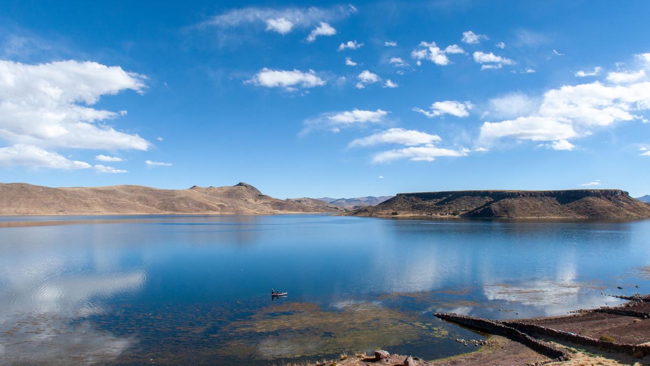 Blue lake with mountains and sky in background