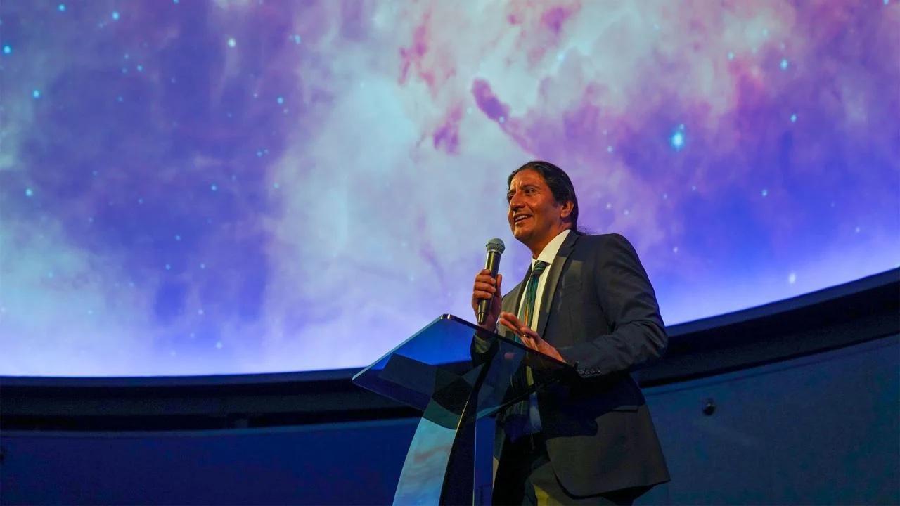 Many in theater surround with sky behind him