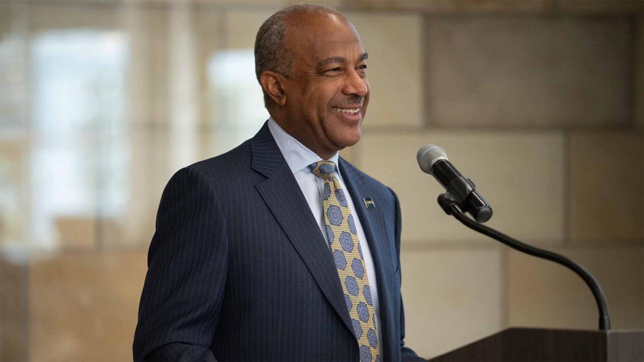 Chancellor Gary S. May speaks at a lectern.