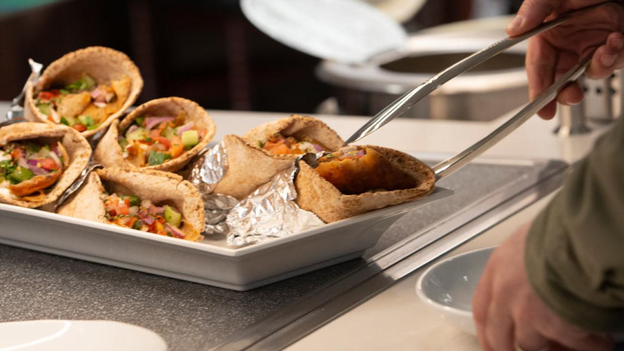 a customer reaches for an empanada on at one of the UC Davis dining commons