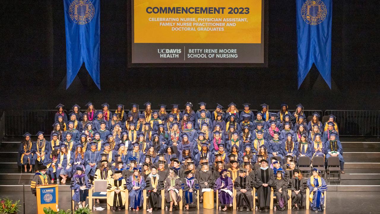 Graduates sit on stage at the 2023 commencement for the Betty Irene Moore School of Nursing