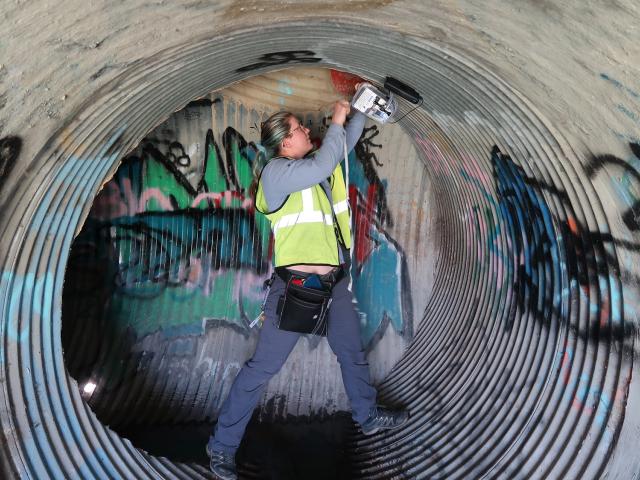 Woman works in a drainpipe