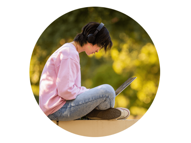 A student working on her laptop outdoors at the UC Davis campus