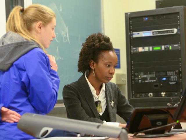 A female professors helps a female student through a difficult problem