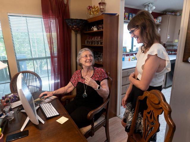 Researcher talks with older patient in her dining room