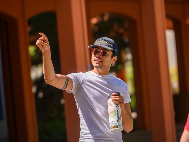 A tour guide pointing out a UC Davis campus landmark