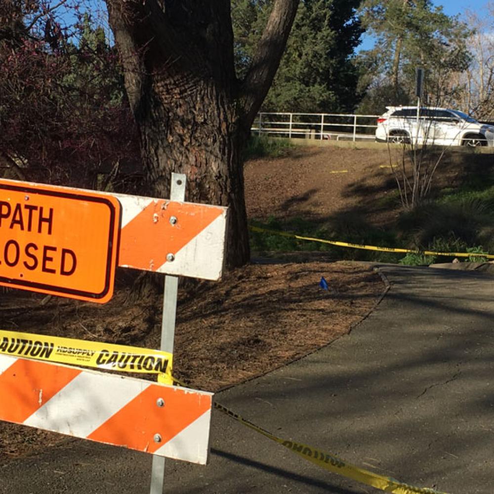 Sign says "Path Closed" on arboretum patrh, near La Rue Road bridge in background.