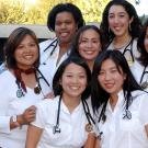 A group of entering medical students (women) with stethoscopes posting together 