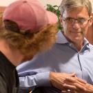 Student in a baseball cap facing a male parent in a discussion